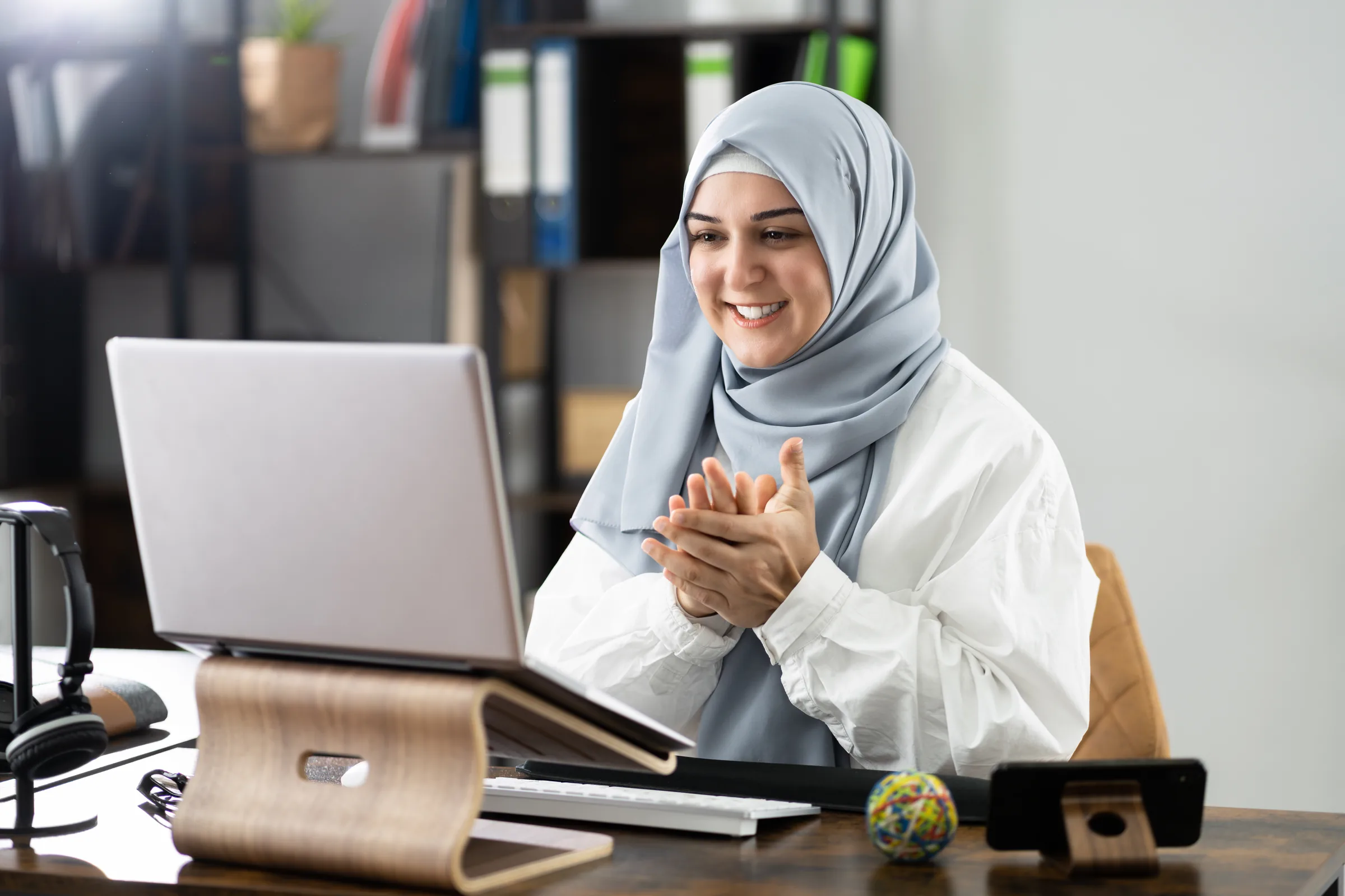Smiling woman at a laptop during a telehealth call